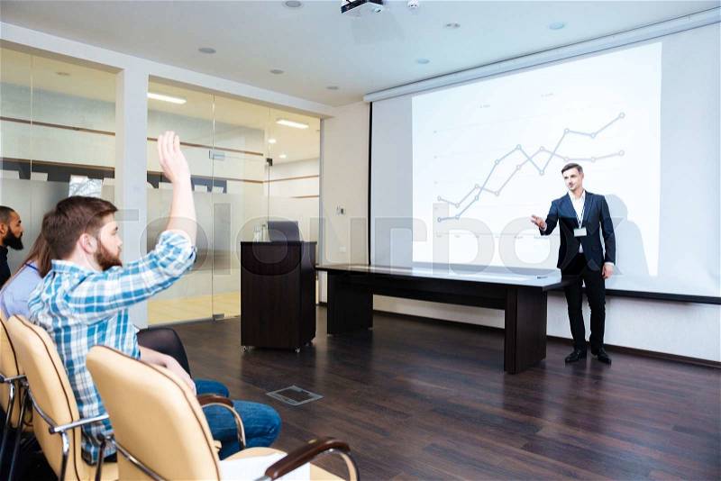 Confident speaker talking to audience on business training in conference hall, stock photo