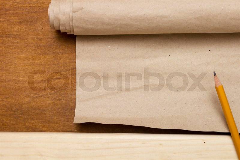 Board, pencil and paper packaging on the wooden table, stock photo