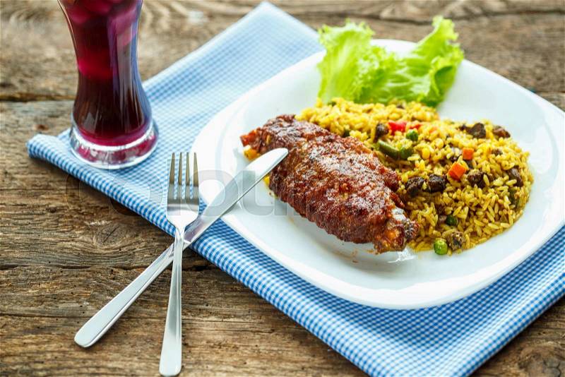 Delicious dishes from turkey meat with rice and salad leaves and a glass of juice with ice, stock photo