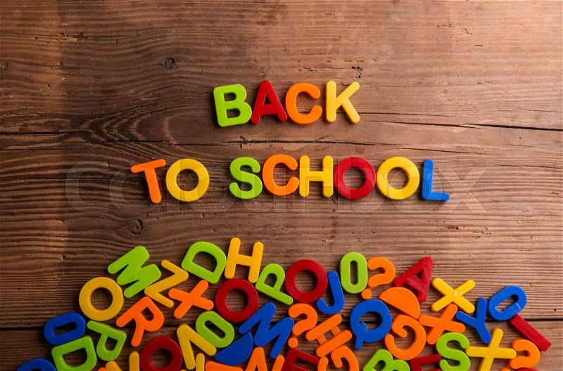 Colorful plastic letters and numbers against wooden background, back to school, stock photo