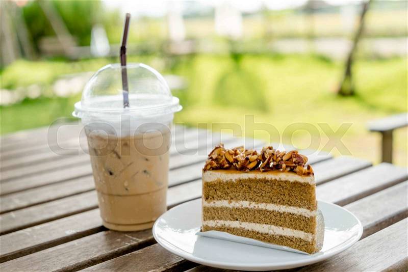 Slice coffee cake with almond nut and butter cream and ice coffee, stock photo