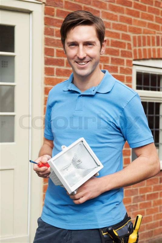Man Fitting External Security Light To House, stock photo