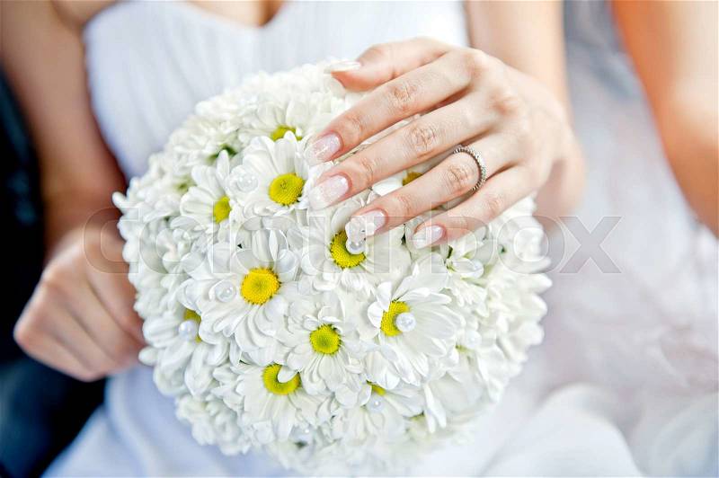 Beautiful wedding bouquet in hands of the bride, stock photo