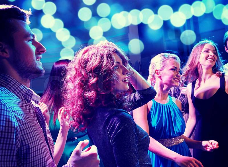 Party, holidays, celebration, nightlife and people concept - smiling friends dancing in club, stock photo