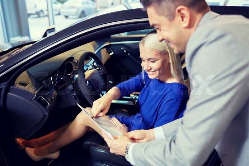 Auto business, car sale, consumerism and people concept - happy woman with car dealer in auto show or salon, stock photo