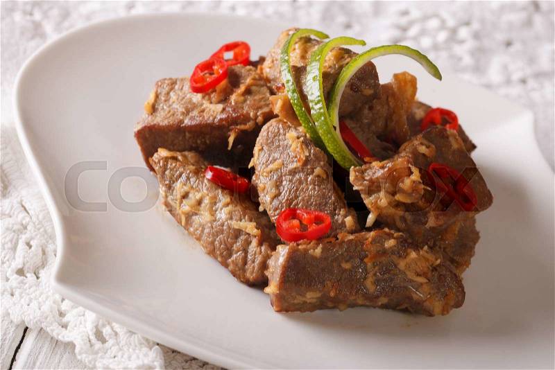 Indonesian cuisine: Beef rendang stewed in coconut milk with spices close-up on a plate. Horizontal , stock photo