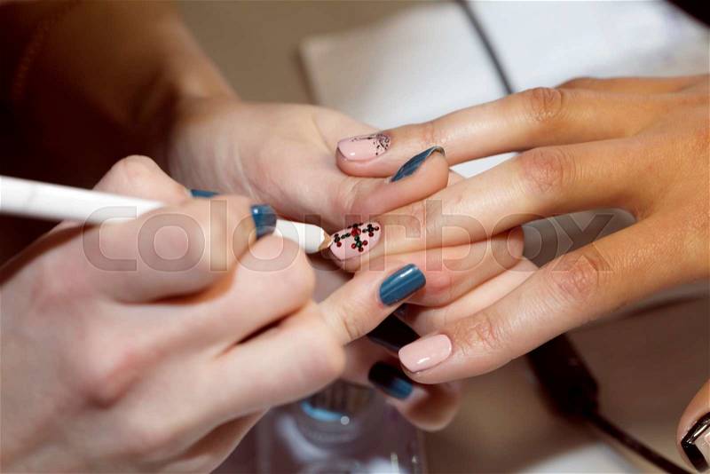 Manicurist makes the new gel polish manicure, close-up, beauty and body care, stock photo