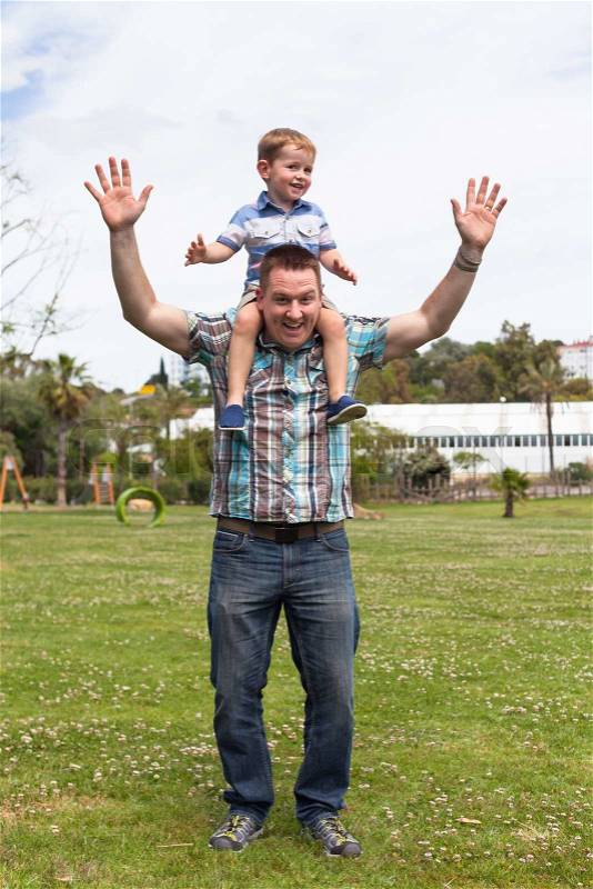 Happy daddy and his son having fun in the park outdoors. Happiness, fatherhood and childhood concept, stock photo