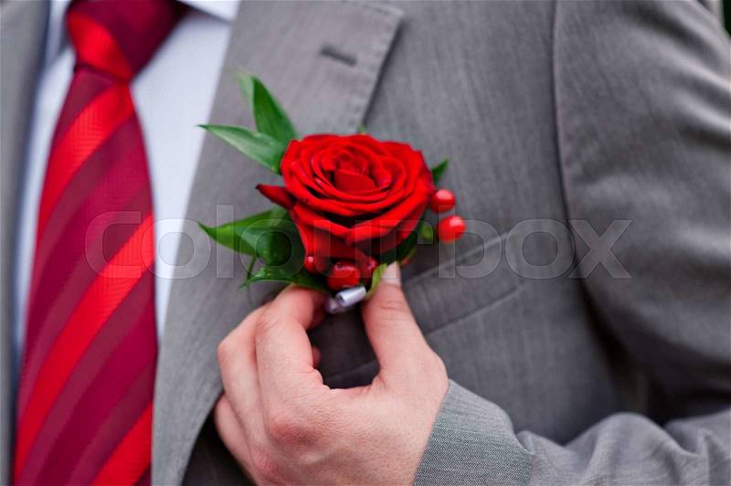 Groom in red tie with rose on his jacket, stock photo