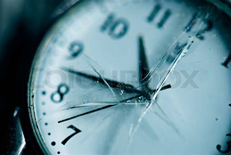 Broken time concept. Old dusty pocket clock with broken glass. Shallow depth of field. Blue tinted image, stock photo