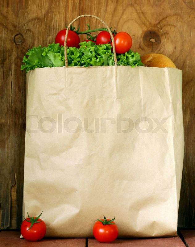 Green salad and fresh tomatoes in a paper bag, stock photo