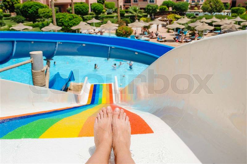Beautiful young woman pulls off the slides in the water park, stock photo