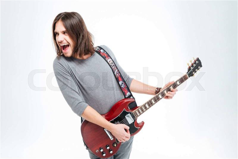 Crazy excited young man screaming and playing electric guitar over white background, stock photo