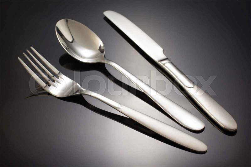 Knife, spoon and fork on black background, stock photo