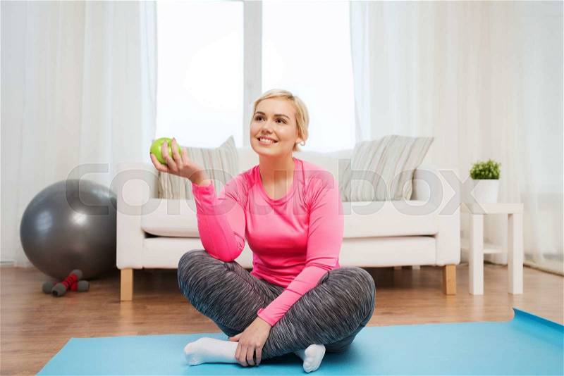 Healthy eating, organic food, diet and people concept - happy woman eating green apple at home, stock photo