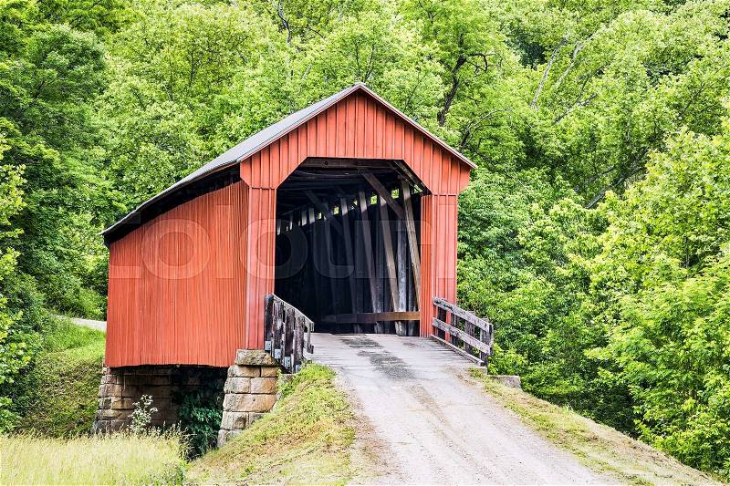 The historic red Hune Covered Bridge, built in 1879, crosses the Little Muskingum River in southeast Ohio\'s Washington County, stock photo