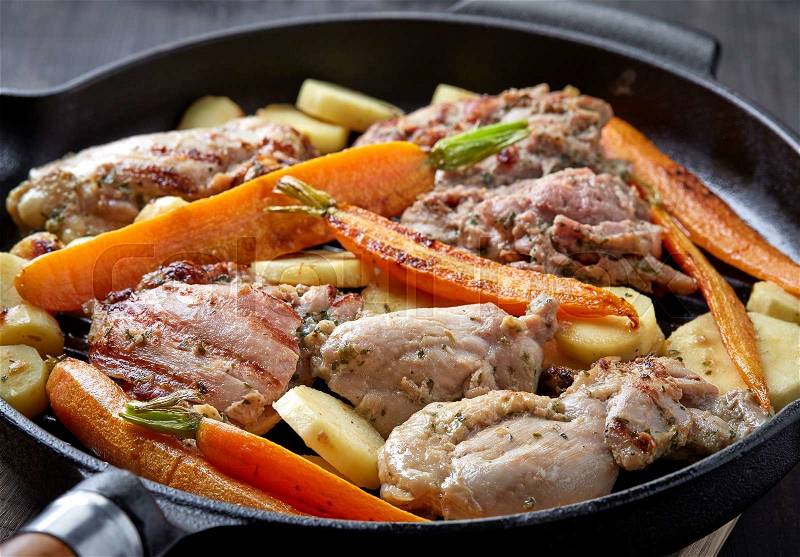 Closeup of chicken meat and roasted vegetables on cooking pan, stock photo