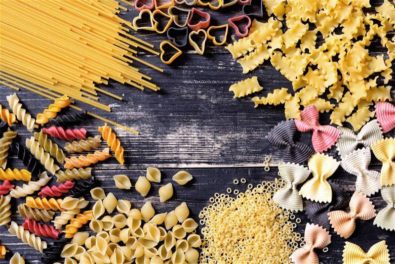 Colored Italian pasta on wooden background , stock photo