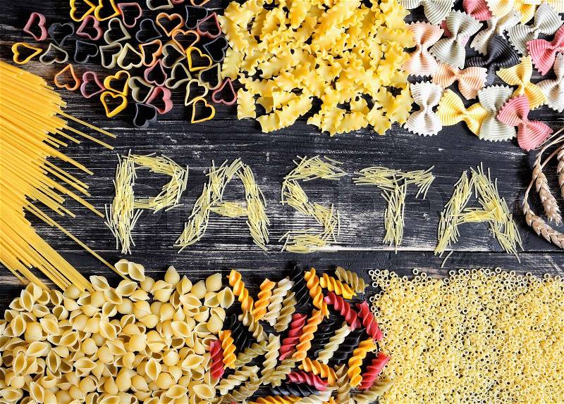 Colored Italian pasta on wooden background , stock photo