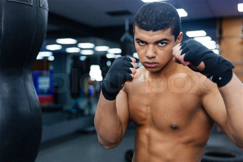 Handsome male boxer workout with boxing bag, stock photo