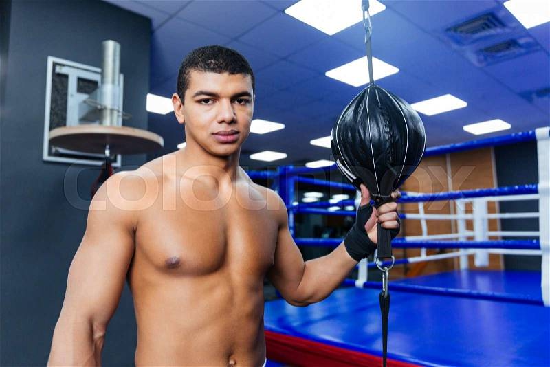 Male boxer standing in gym and looking at camera, stock photo