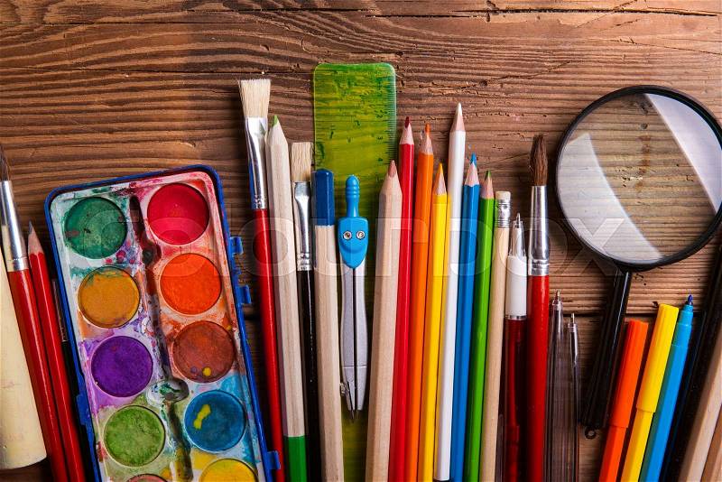 Various school and art supplies laid on table, flat lay. Studio shot on wooden background, stock photo