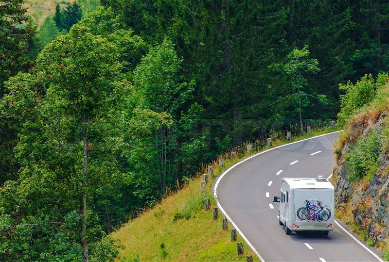 Camper Journey. Small Class B Camper Van with Whole Family Bikes on the Forest Road. Camper Travel Theme, stock photo