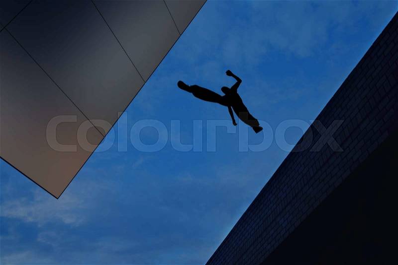 Man jumping from roof to roof concept of risk taking and challenge, stock photo