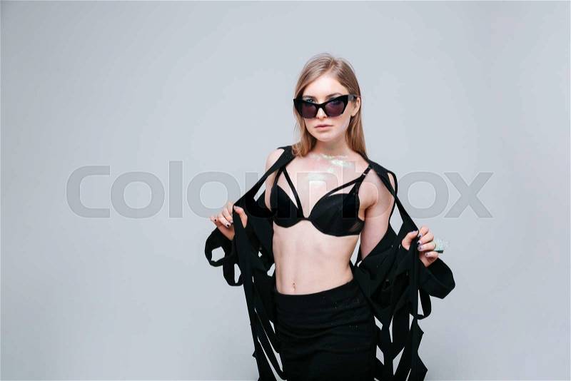 Charming woman in fashion cloth posing over gray background, stock photo