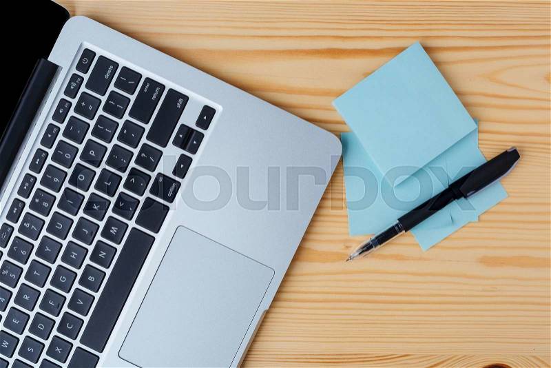 Top view of laptop, pen and stickers on the table, stock photo