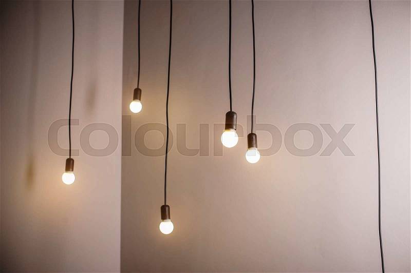 Many lamps on a long cord and hanging light in the room, stock photo