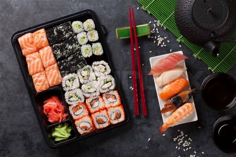 Set of sushi and maki roll and green tea on stone table. Top view, stock photo