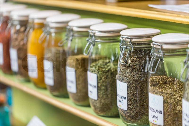 Assortment of glass jars on shelves in herbalist shop in marrakesh, morocco, containing herbs and spices for medicinal and culinary purposes , stock photo