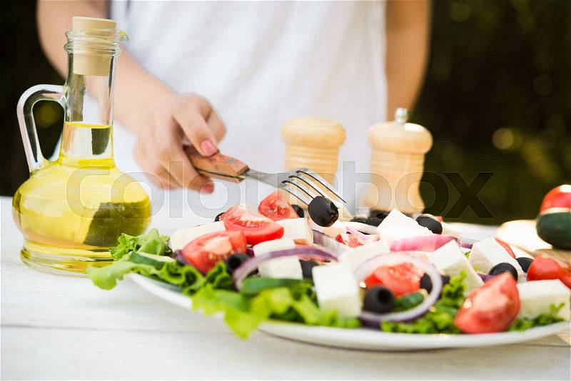 Fresh Caesar salad on white wooden table in the garden. Cooking outdoors, stock photo