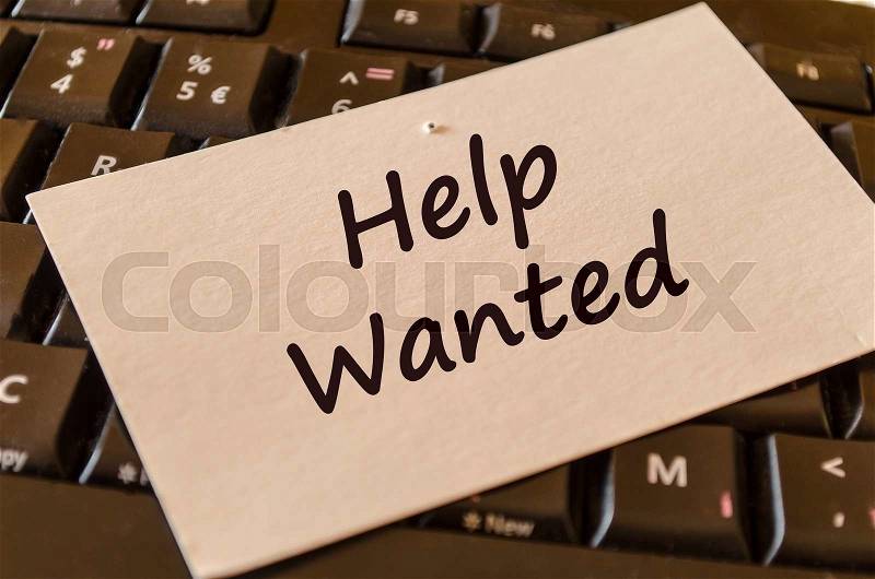 Computer Keyboard with white note and text help wanted, stock photo
