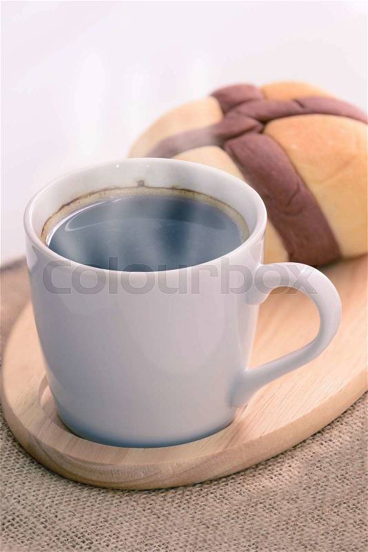 Hot coffee and bread on wooden coaster, stock photo
