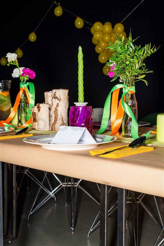 Decorated table in mexican style ready for dinner. Beautifully decorated colorful table set with flowers, candles, plates and serviettes for wedding or another event in the restaurant, stock photo