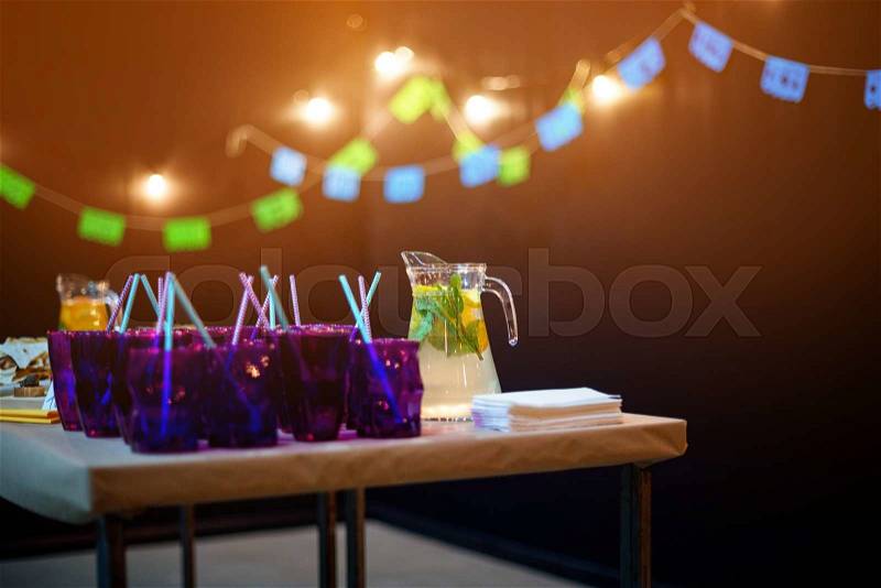A carafe of fruity beverage with mint and lemon on a decorated table ready for dinner. Beautifully decorated table set for wedding or another event in the restaurant, stock photo