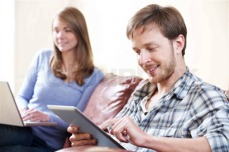 Couple Using Digital Technology At Home, stock photo