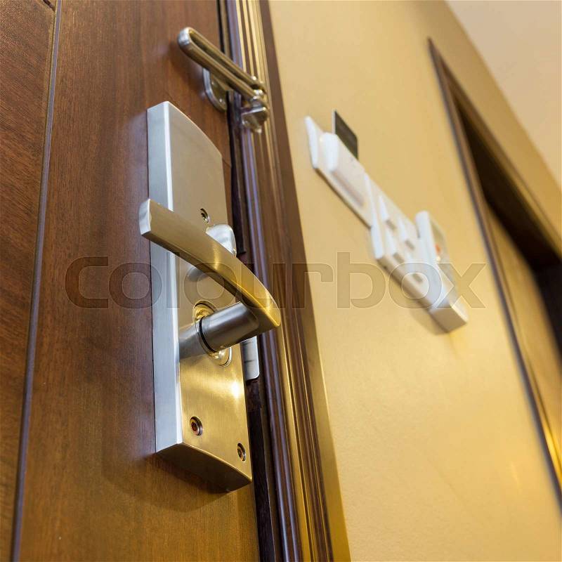 Metal door handle on wooden door, stock photo