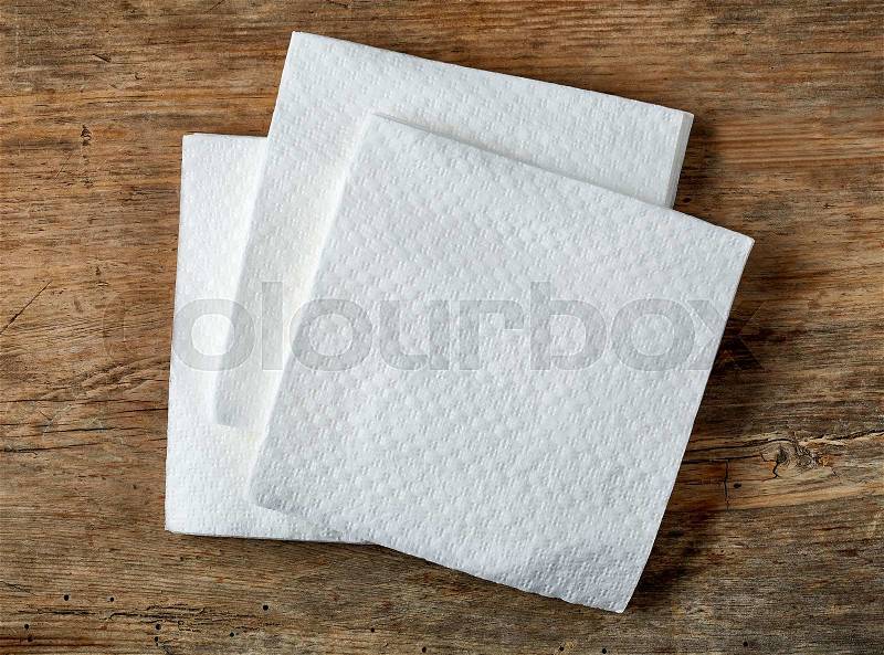 White paper napkin on wooden table, top view, stock photo