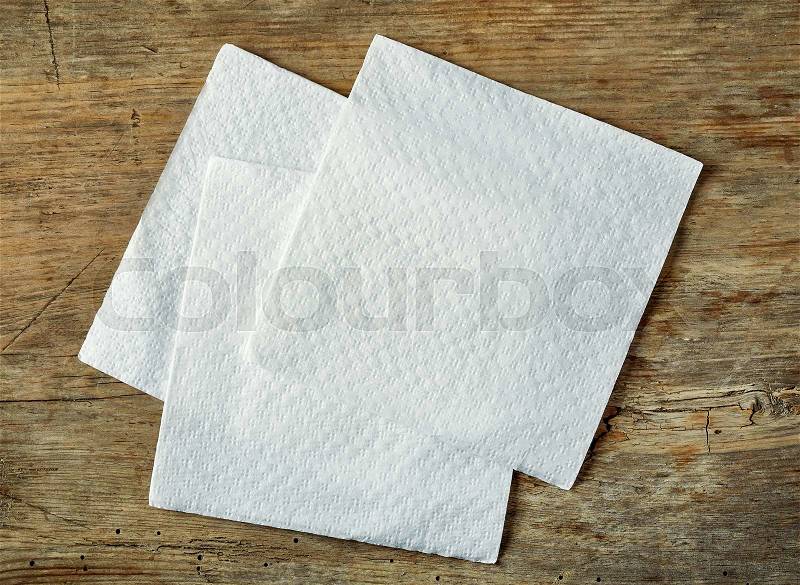 White paper napkin on wooden table, top view, stock photo