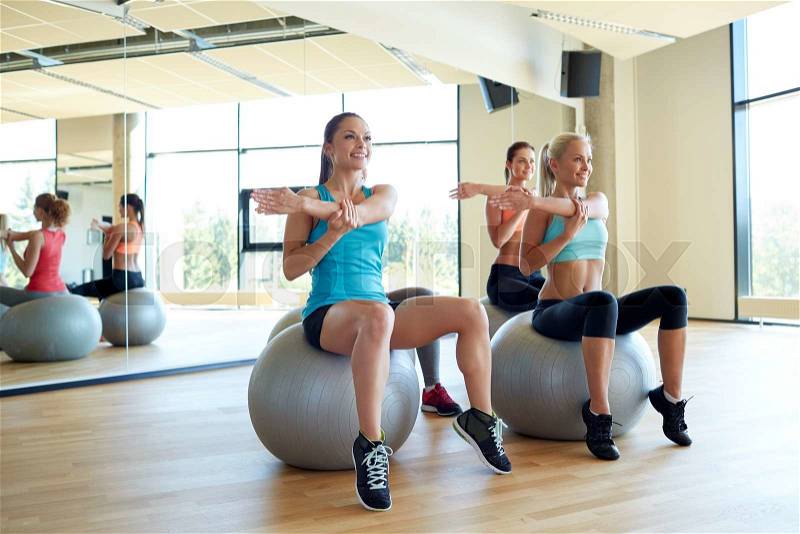 Fitness, sport, training and lifestyle concept - group of smiling women with exercise balls in gym, stock photo