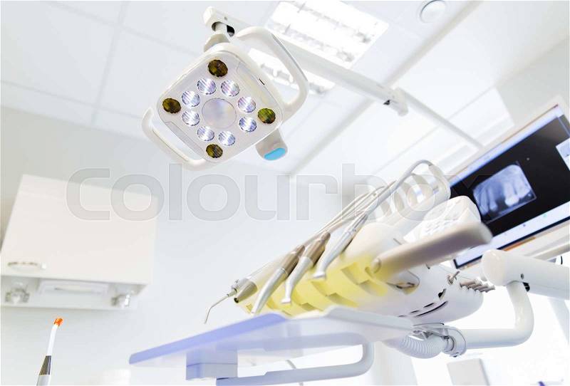 Dentistry, medicine, medical equipment and stomatology concept - close up of lamp and dental unit instruments clinic office, stock photo