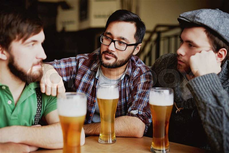 Company of friendly men spending time in pub, stock photo