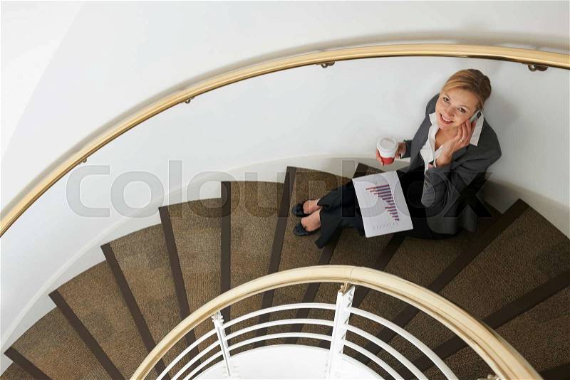Businesswoman Sitting On Stairs On Mobile Phone, stock photo