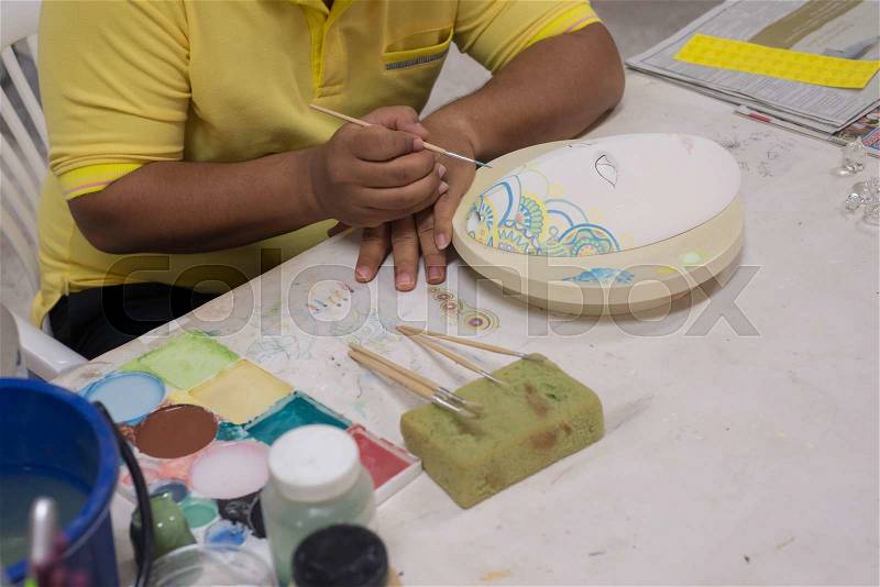 Artist hand painting unfinished art mask, stock photo