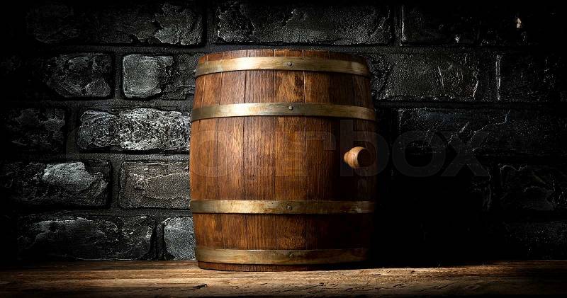 Wooden barrel and black brick wall in cellar, stock photo