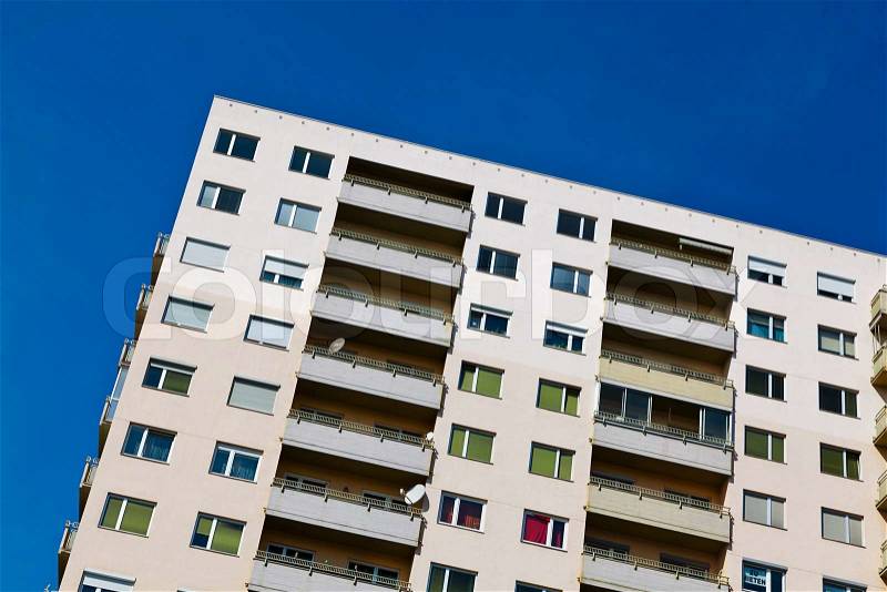 A high-rise building as a residence with balconies in a city, stock photo