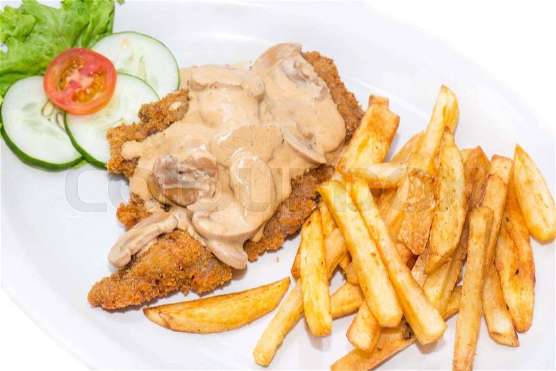 Schnitzel with mushroom sauce and french fries on a white background in the restaurant, stock photo